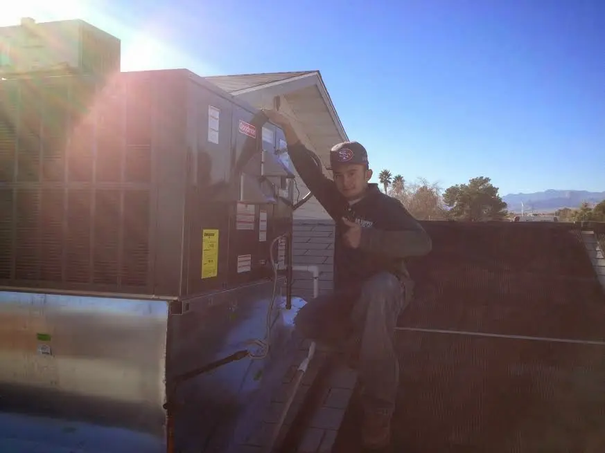 HVAC technician performing Air Duct Cleaning on a rooftop unit in Bon Air